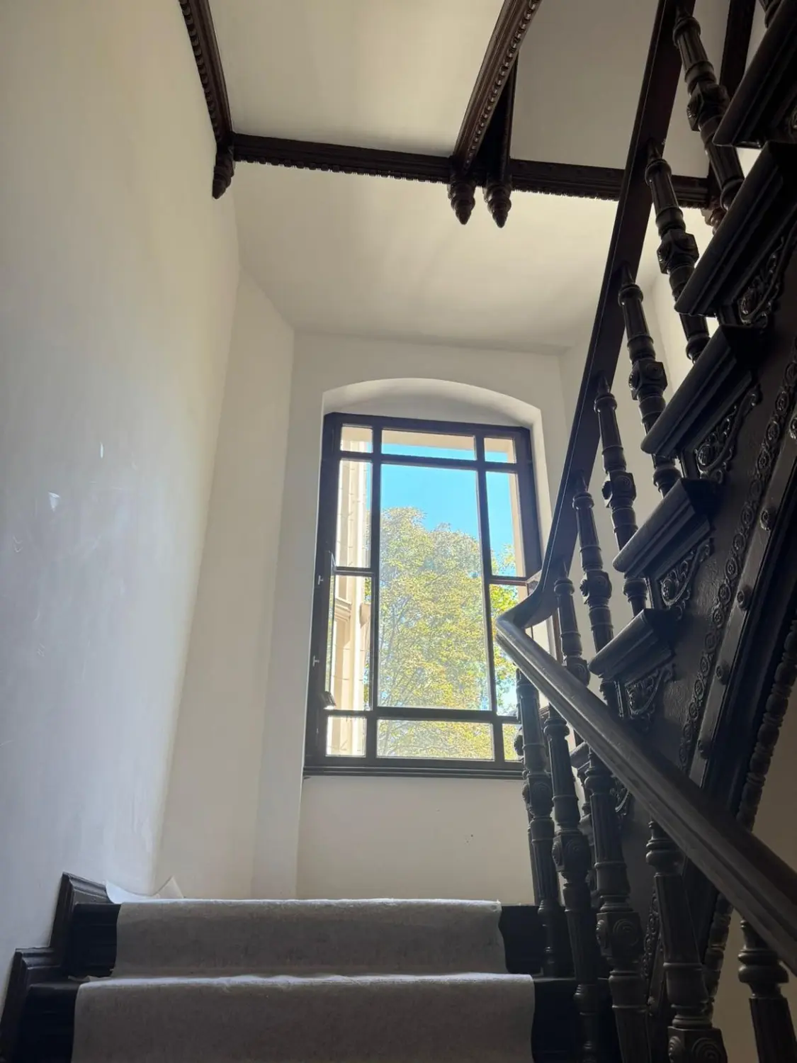 Historisches Treppenhaus mit dunkler Holzbrüstung